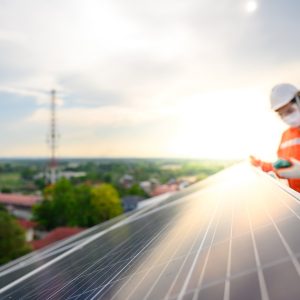 Male Engineer Industrial Technician Inspect Solar Panel Electricity With digital insulation tester At industrial plants that install solar panels using solar energy